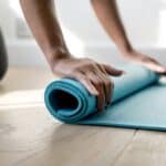 Frau rollt Yogamatte