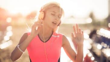 Junge Frau genießt Musik am Strand