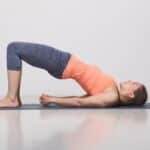 Schönes sportlich fittes Yogi-Girl übt Yoga-Asana-Setu-Bandhas