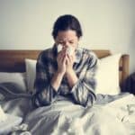 Eine an Grippe erkrankte Frau im Bett