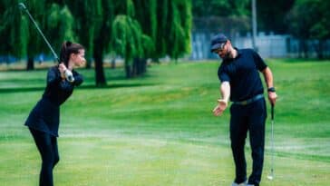 Golf spielen. Junge Frau spielt Golf mit Golflehrer