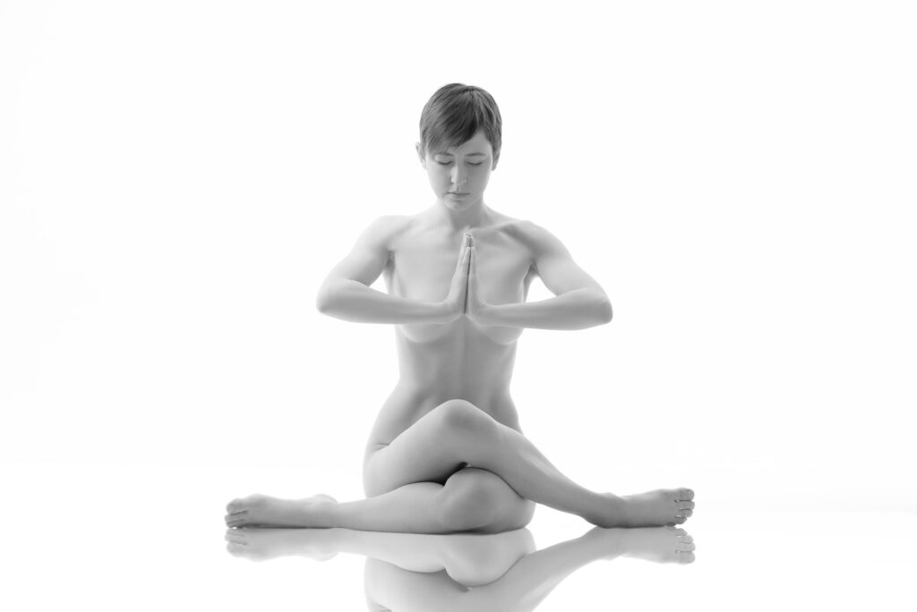 Junge nackte Frau meditiert in einer Yogapose